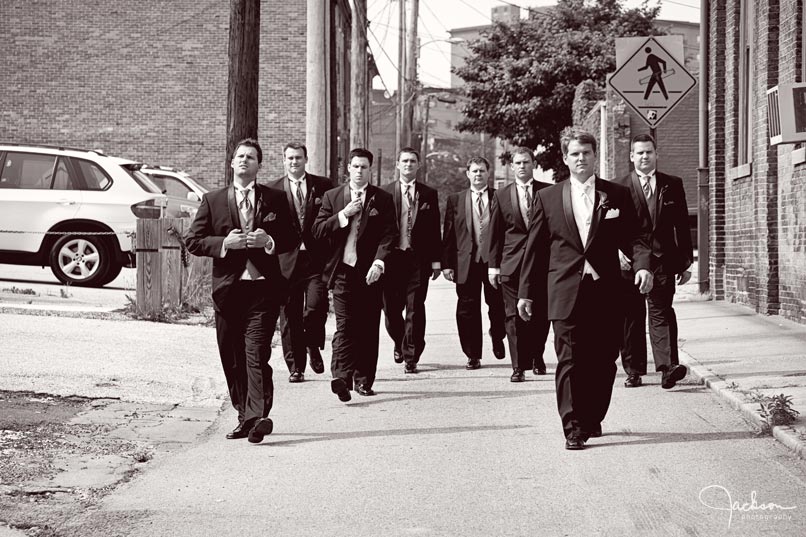groom and groomsmen walking down alley