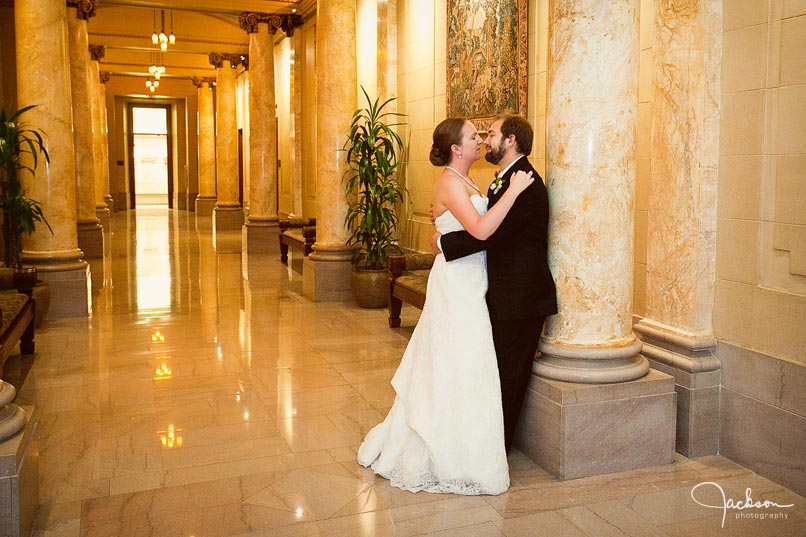 bride and groom leaning on column