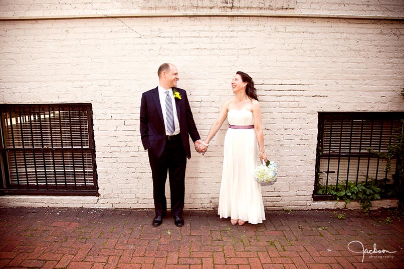 bride and groom posing along Chase Court's wall