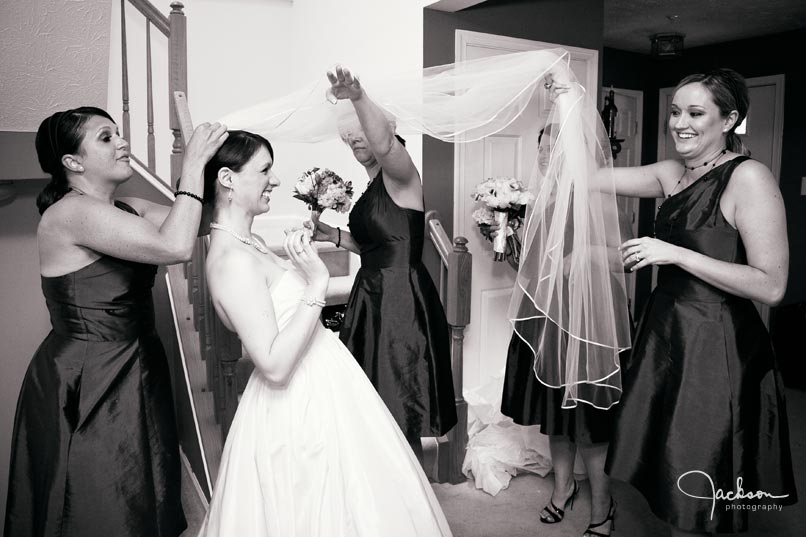 bridesmaids putting on bride's veil