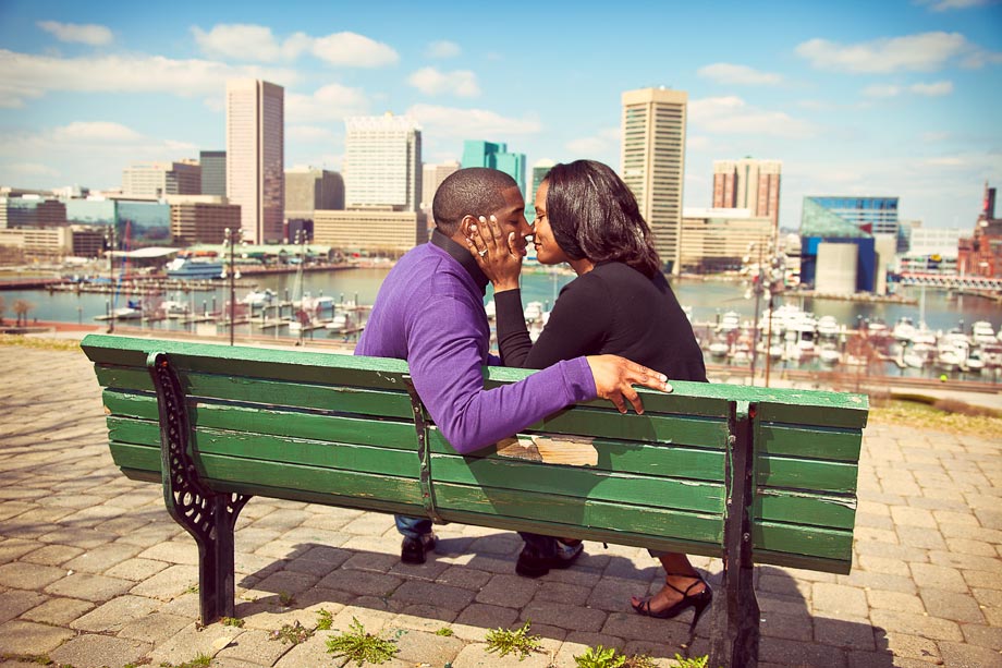couple kissing on green park bench