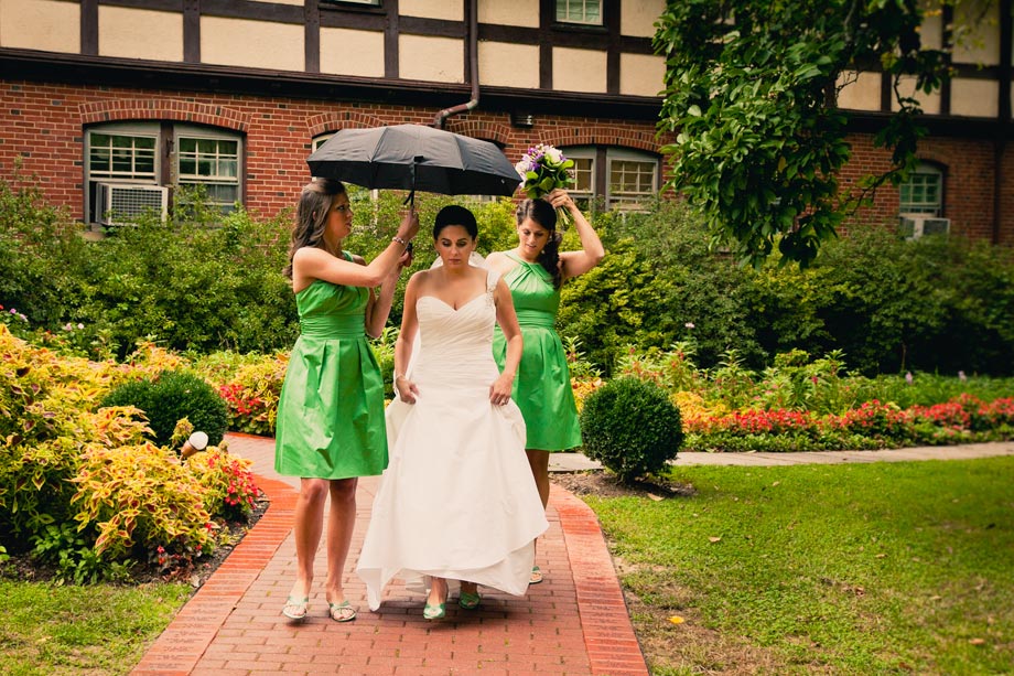 bride with green bridesmaid dresses under umbrella