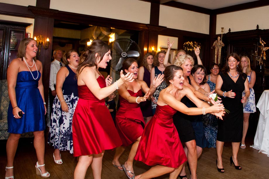 bridesmaids in red catching bouquet