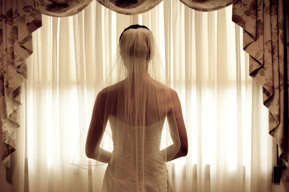 bride silhouetted against window