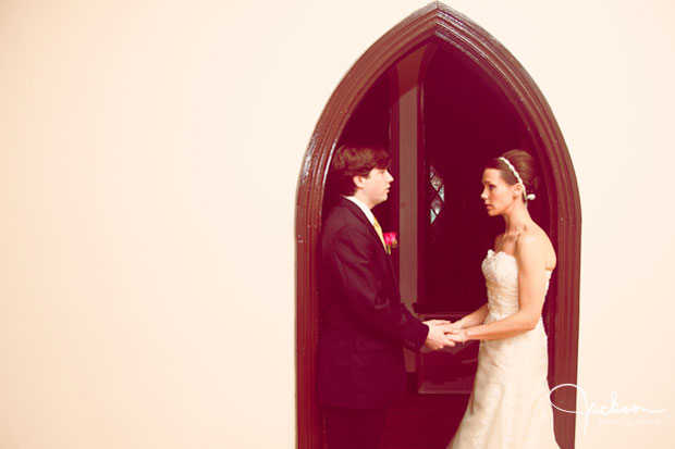 Bride and Groom holding hands under archway