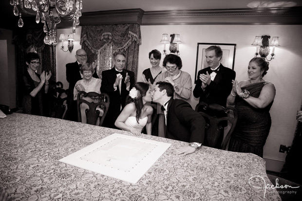 bride and groom kissing at ketubah signing