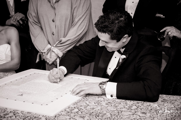 groom signing the ketubah