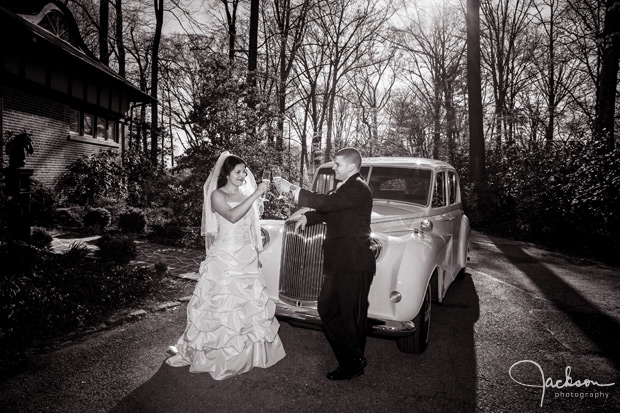 bride and groom toasting in front of rolls royce