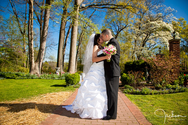 bride and groom kissing on path