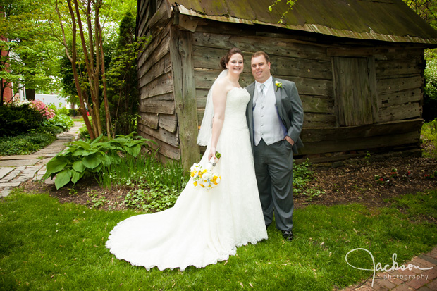 bride and groom posing in front of rustic shed