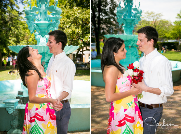 couple engaging in front of blue fountain