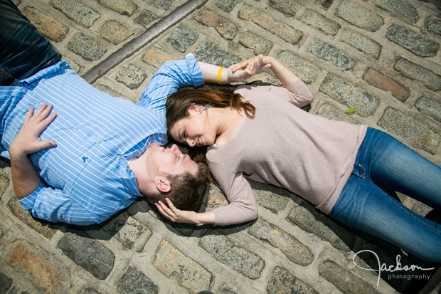 man and woman laying on cobblestone