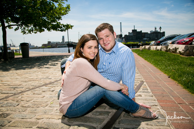 couple sitting on cobblestone road