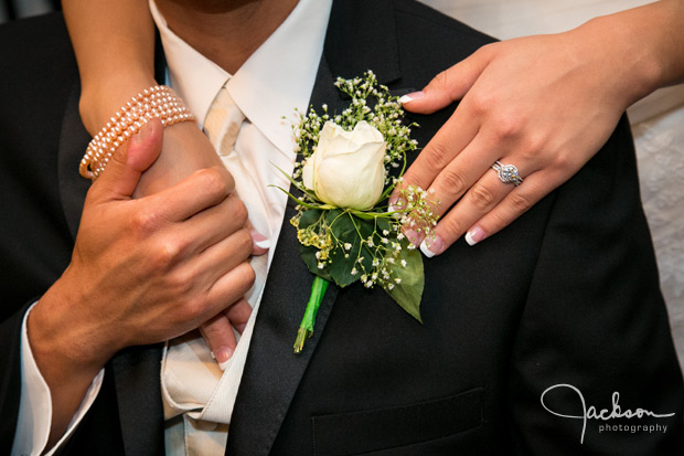 white rose boutonniere with hands and rings 