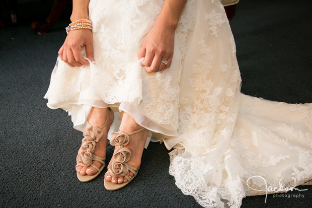bride showing brown flowered lace shoes