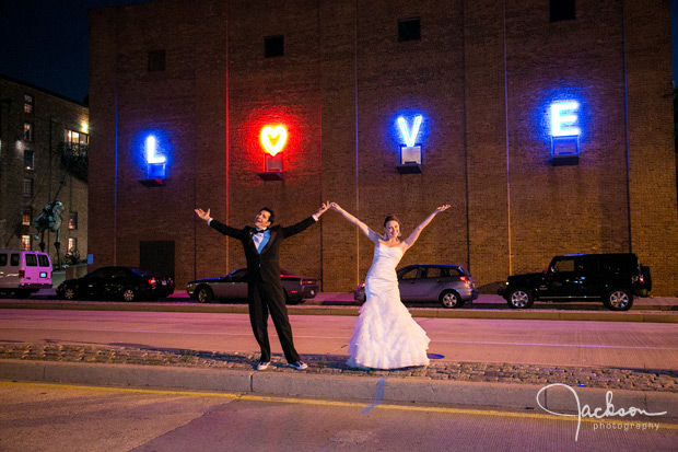 bride and groom on key highway in front of AVAM LOVE neon