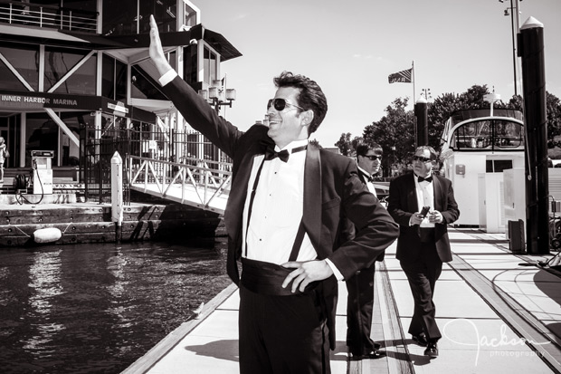 groom waving to bride on boat dock