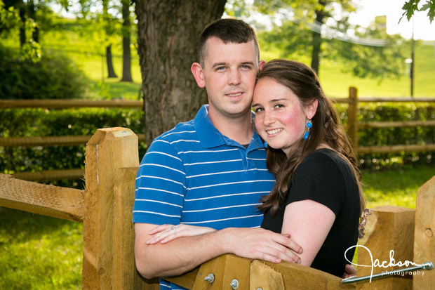 couple leaning on wooden fence
