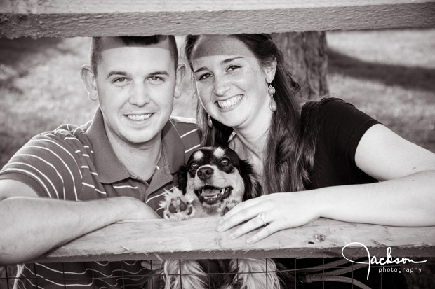 couple between fence posts with dog