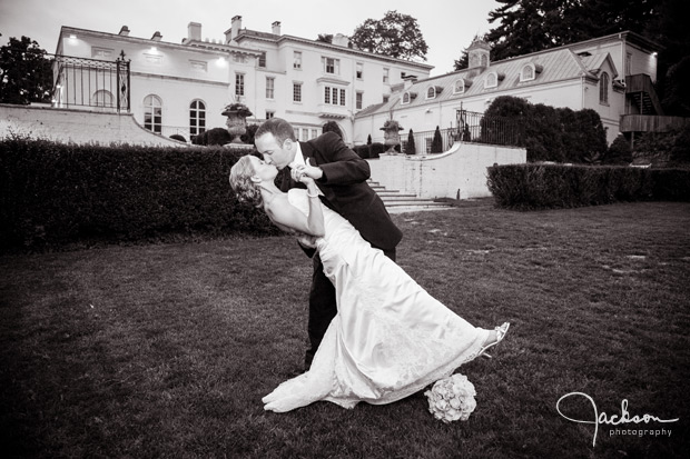 bride and groom in front of evergreen house