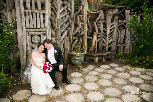 bride and groom sitting on tree stump at AVAM garden