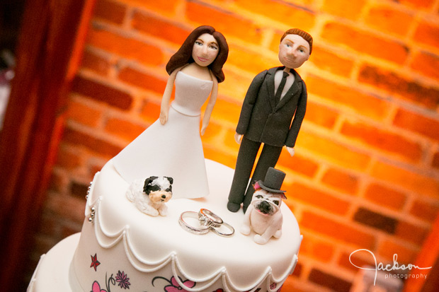 cartoonish cake topper of bride and groom with dogs