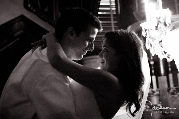 bride and groom close by chandelier 