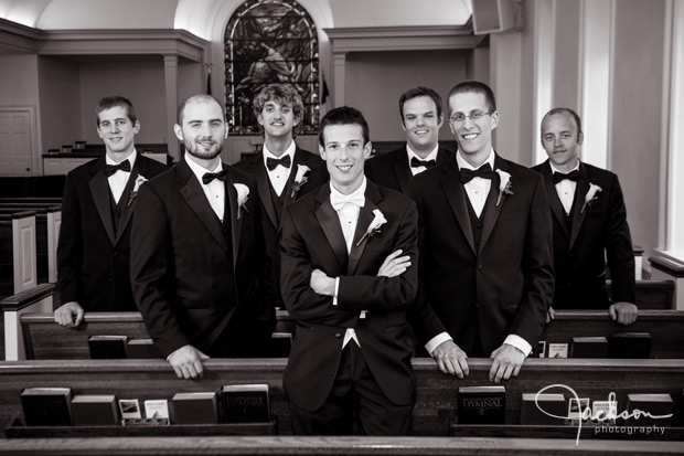 groom and groomsmen amongst church pews