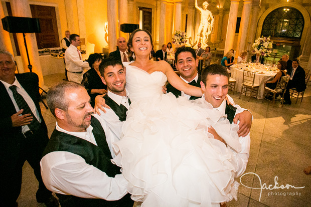 groom and friends carrying bride