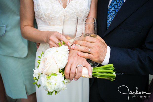 bride and groom's hands with rings and flowers