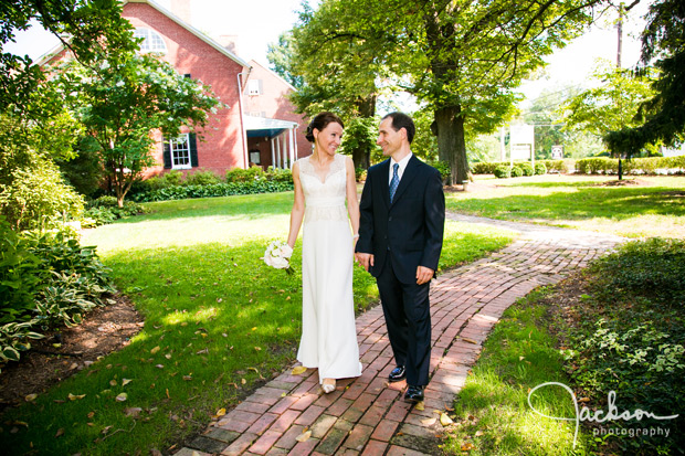 bride and groom walking along brick path