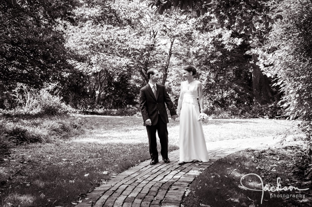 bride and groom walking along garden path
