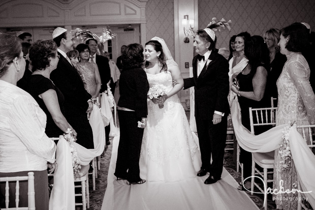 bride walking down the aisle kissing mom