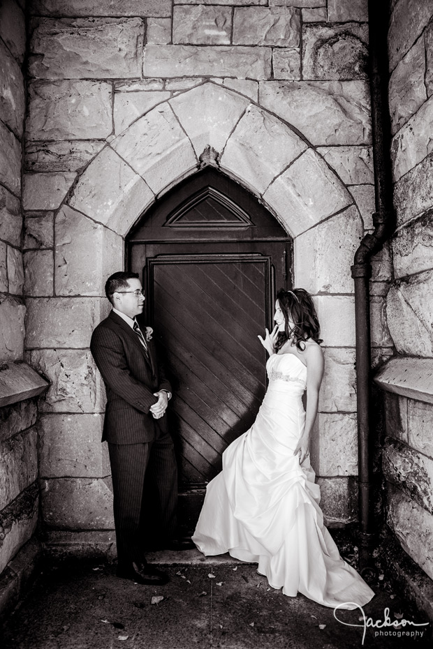 bride and groom by grungy stone wall and door