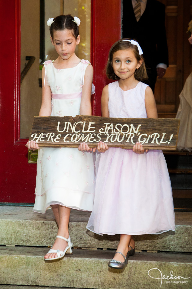 flower girls holding wooden sign