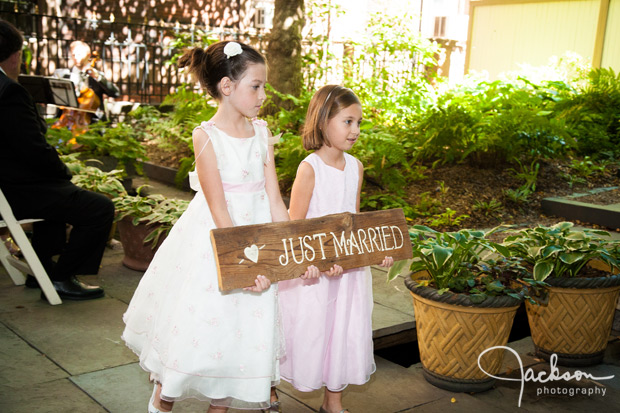 flower girls leaving with wooden sign