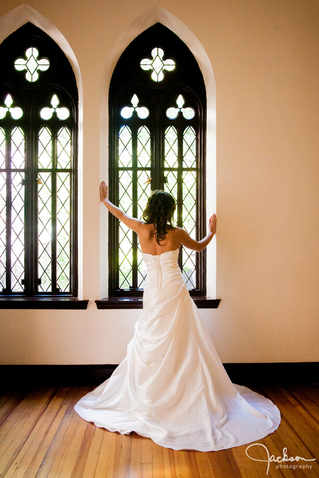 bride in dramatic pose by window