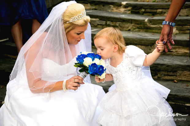 bride letting flower girl smell bouquet
