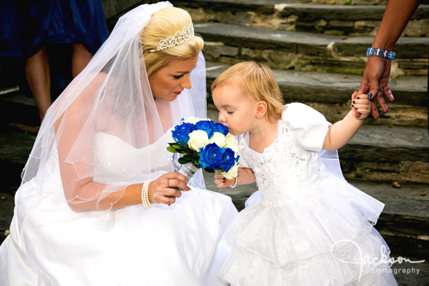 bride letting flower girl smell bouquet