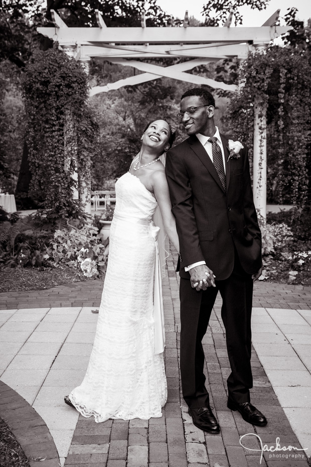 bride and groom posing and laughing black and white