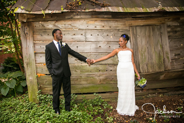 bride and groom by grey barn