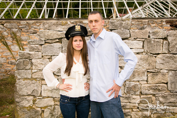 police man and fiance in front of old stone wall