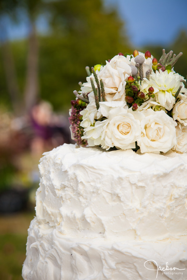 detail of white stucco cake and green brown flowers