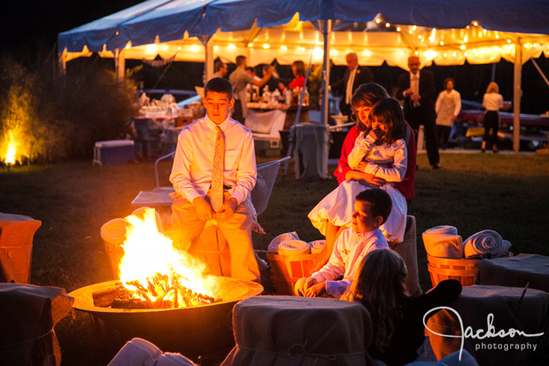 people sitting at campfire at wedding reception