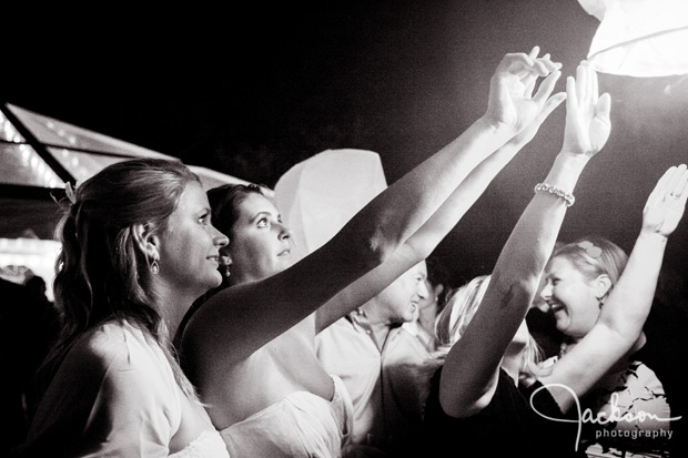 bride letting a paper balloon fly into the night