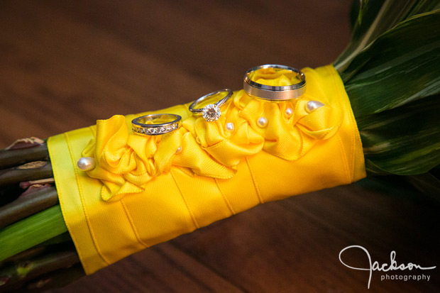 bride and groom rings on yellow bouquet wrappings