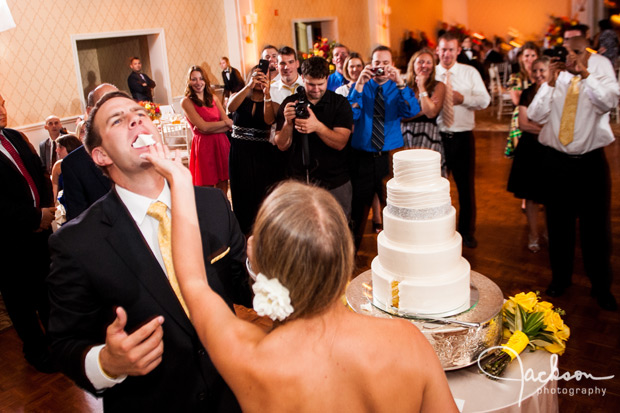 bride shoving cake in the face of the groom