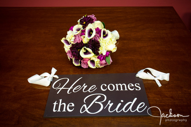 bridal bouquet with here comes the bride sign just married