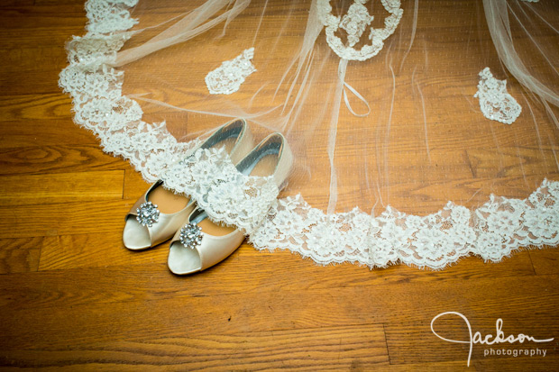 bride's white silver shoes with veil over them