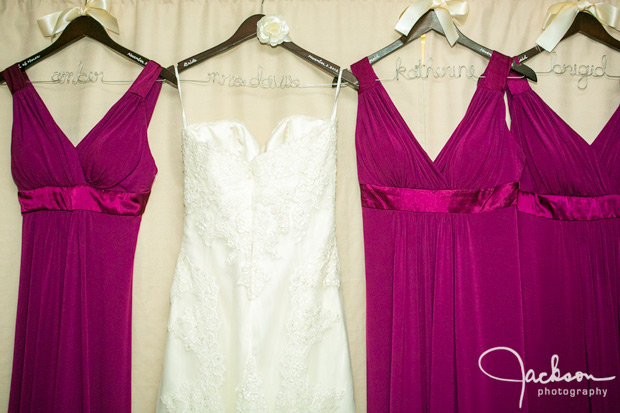 bride and pink bridesmaid dresses hanging on named hangers